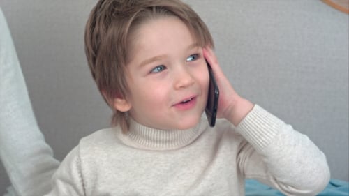 Happy Child Talking on Smartphone Indoors