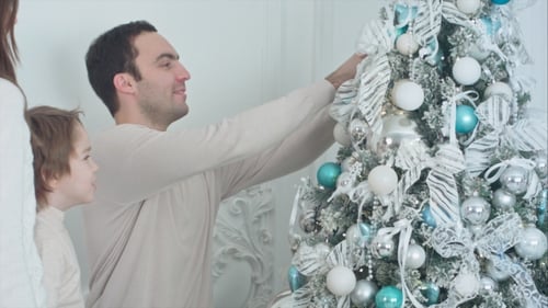Family Decorating Christmas Tree at Home Together