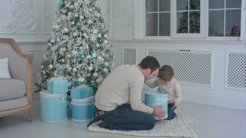 Father and Son Opening Christmas Gifts at Home