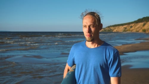 a Man with a Yoga Rolls Walking on the Beach