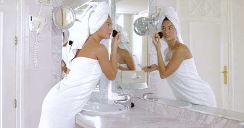 Woman Applies Makeup in Bright Bathroom
