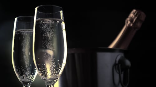 Two Champagne Flutes with Bubbles and Champagne Bottle