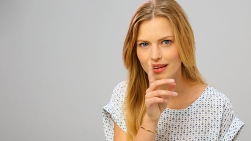 Smiling Woman Gesturing in a Studio Setting