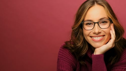 Smiling Woman Wearing Glasses Posing Indoors