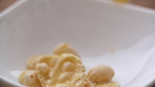 Corn Flakes Falling in White Bowl in . View