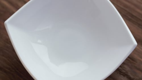 Corn Flakes Falling in White Bowl. Center View