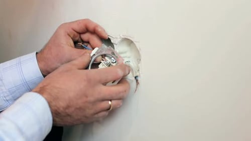 Technician Installs Electrical Outlet Close Up