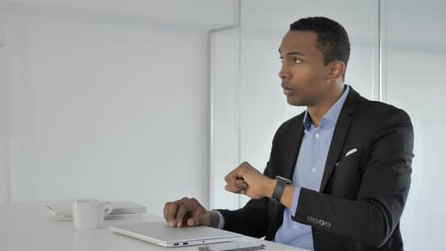 Young Adult Man Waiting at Desk in Office
