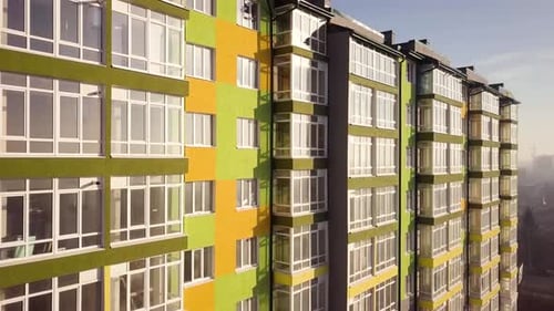 Aerial footage of a tall residential apartment building with many windows and balconies.
