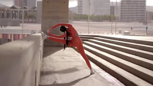 Young Adult Stretches Against Wall in City