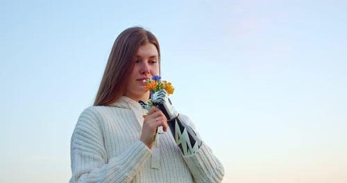 Woman with Prosthetic Arm Holding Wildflowers