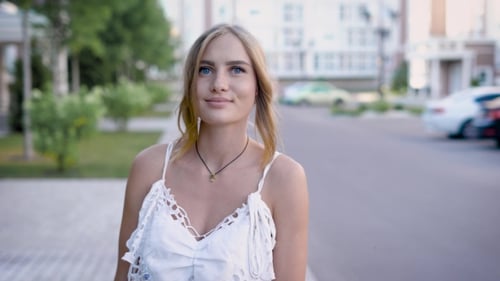 Smiling Blonde Woman in White Top Outdoors