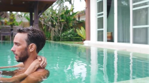 Couple Embracing in Tropical Swimming Pool