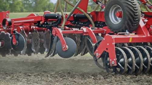 Sowing Machine Working on Farming Field. Farming Tractor with Trailer Seeder