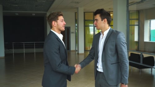 Two Businessmen Met in the Office and Shake Hands