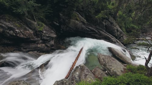 Gebirgsfluss mit Kaskadenwasserfall im Wald