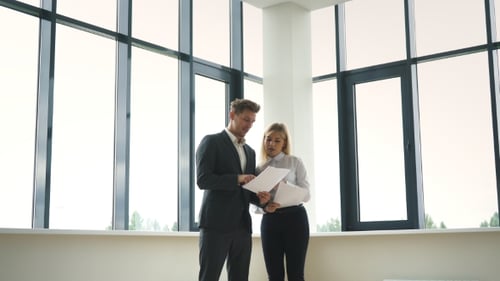 Empresarios exitosos discutiendo el plan de negocios cerca de la ventana