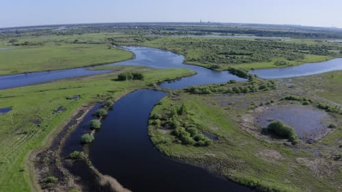 Scenic Aerial View of a River and Green Fields in a Countryside