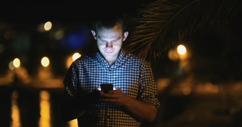 Young Adult Using Mobile Phone at Night