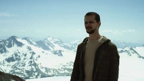 Young Bearded Man Giving Instructions at Snowy Mountains with Scenic View