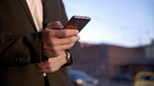 Businessman Uses Modern Mobile Phone on the Street