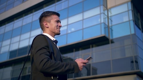 Young Handsome Businessman Talking on Mobile Phone in the City