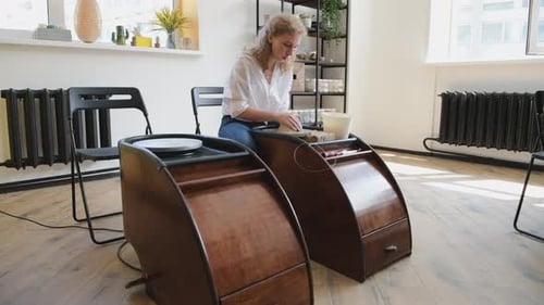 Woman Shaping Clay on a Pottery Wheel in Studio