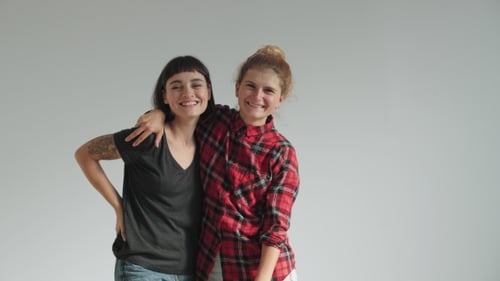 Two Cheerful Women Hugging in a Studio