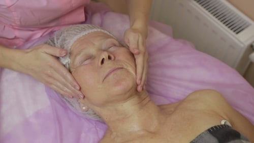 Relaxed Elderly Woman Getting Spa Face Treatment