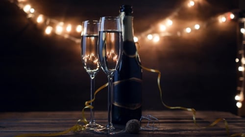 Dos flautas con vino espumoso sobre fondo parpadeante Bokeh de vacaciones