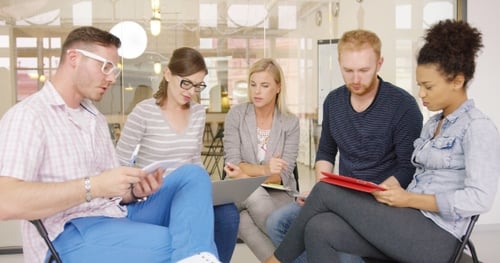 Five Adults Discussing Project in Workplace Setting