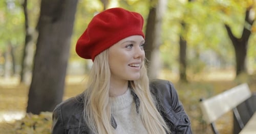 Stylish Woman with Red Beret Smiles in Park