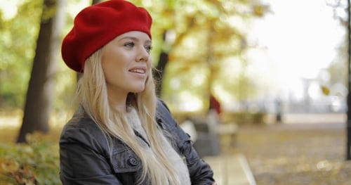 Stylish Woman in Red Beret Sitting in Park