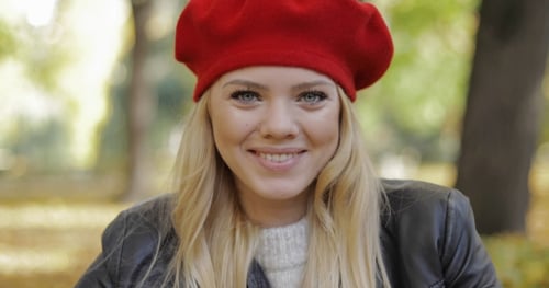 Beautiful Woman Smiling in a Park Wearing Beret
