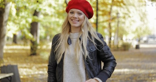 Blonde Woman in Red Beret Walking in Autumn Park