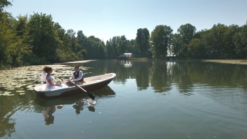 Aerial View on Couple Is Floating on a Boat on the Lake in Wood