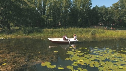Top View on Couple Is Floating on a Boat on the Lake in Wood