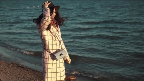 Stylish Woman Walking Along a Sunny Beach