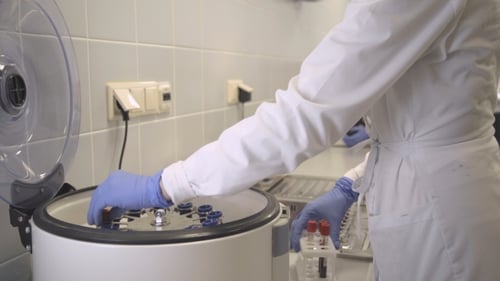 Scientist Using Centrifuge in Medical Laboratory
