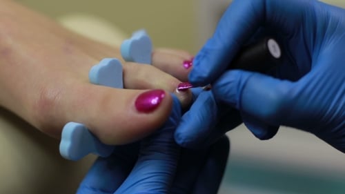 Applying Pink Nail Polish During Pedicure