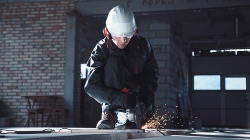 Adult Using an Angle Grinder in Industrial Garage