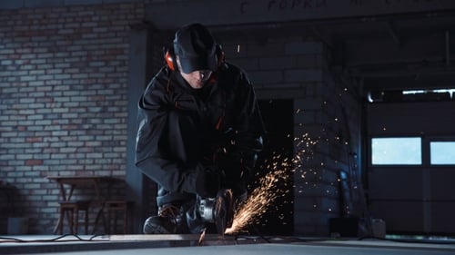 Man Cutting with Grinder in Hangar