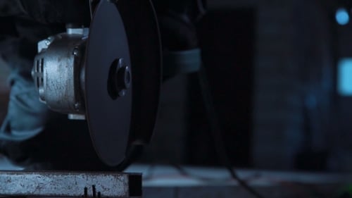 Unrecognizable Worker Cutting with Angle Grinder