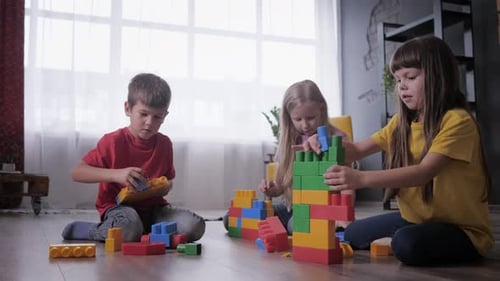 Three Children Playing with Colorful Building Blocks Indoors