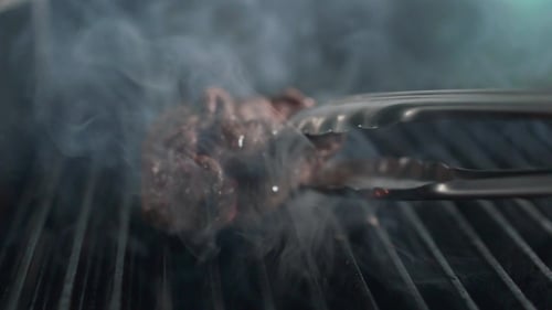 Chef Turns Over the Roasting Beef Steak Over, Smoke and Fire, Grilled Meat