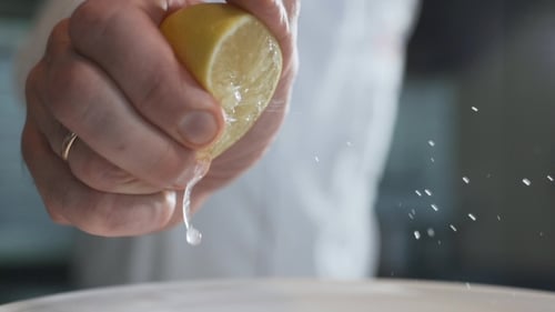 Hands Squeezing Fresh Lemon Juice Close Up