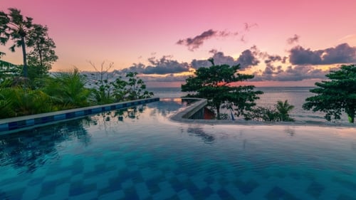 Magnifique coucher de soleil tropical sur la piscine à débordement à Bali