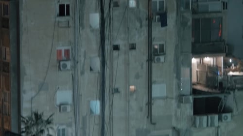 Casa de vários andares desgastada com festa noturna no telhado