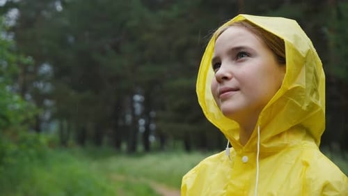 Pensive Girl Looks Away Enjoying Rainy Weather in Forest
