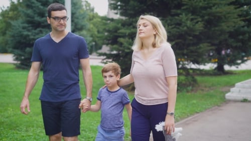 Cheerful Mother and Father with Little Son Walking on Park in Summer